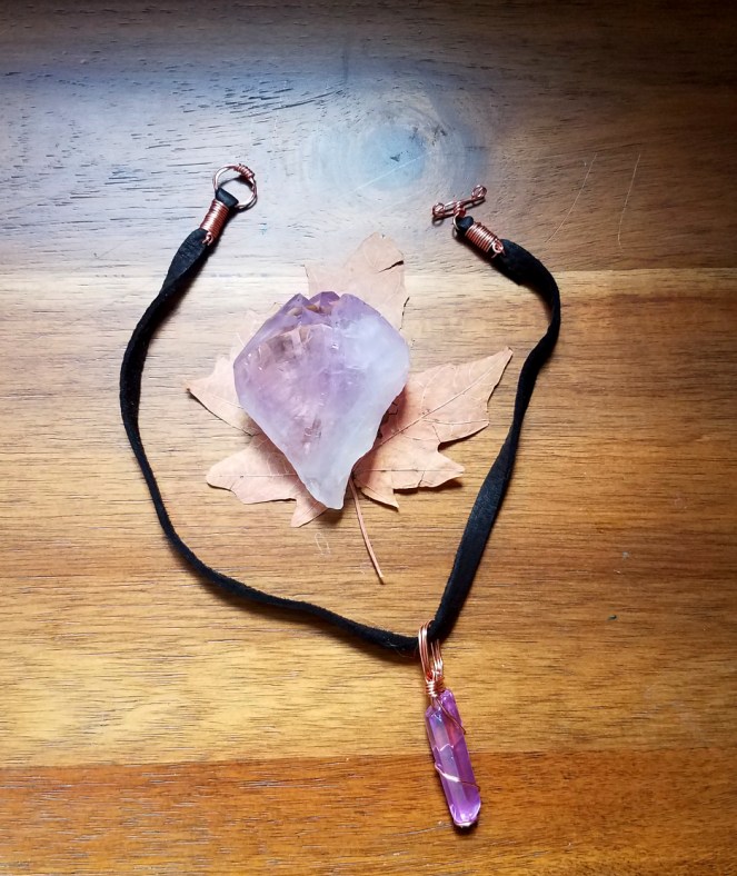 A purple aura quartz necklace.