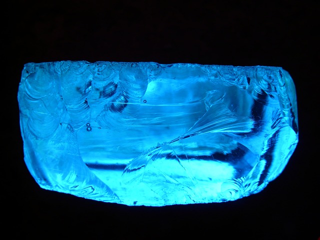 A chunk of blue glass on a black background. 