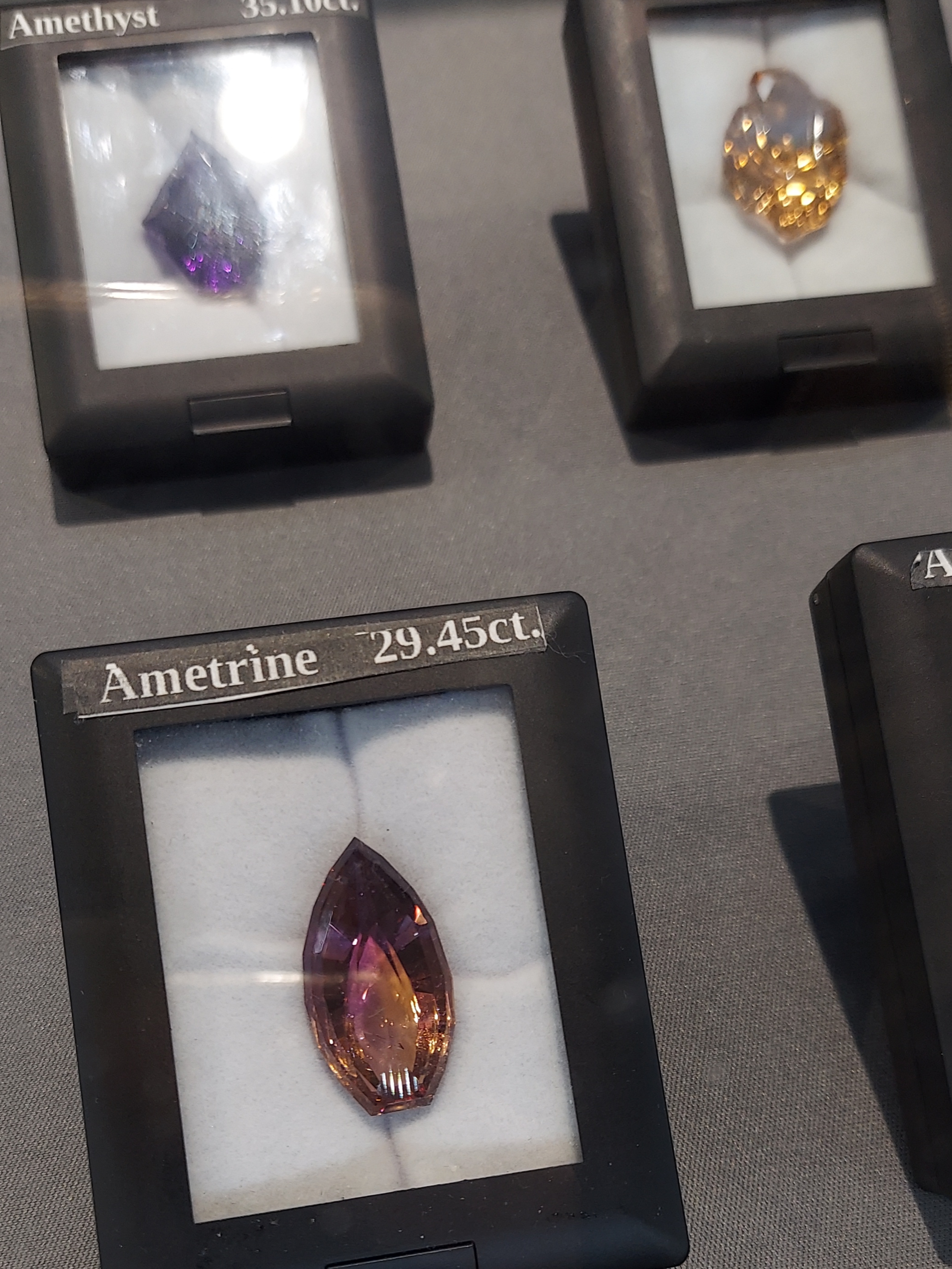 Several faceted specimens for use in jewelry. There's a bright purple amethyst, a bright yellow citrine, and a beautifully color zoned ametrine.