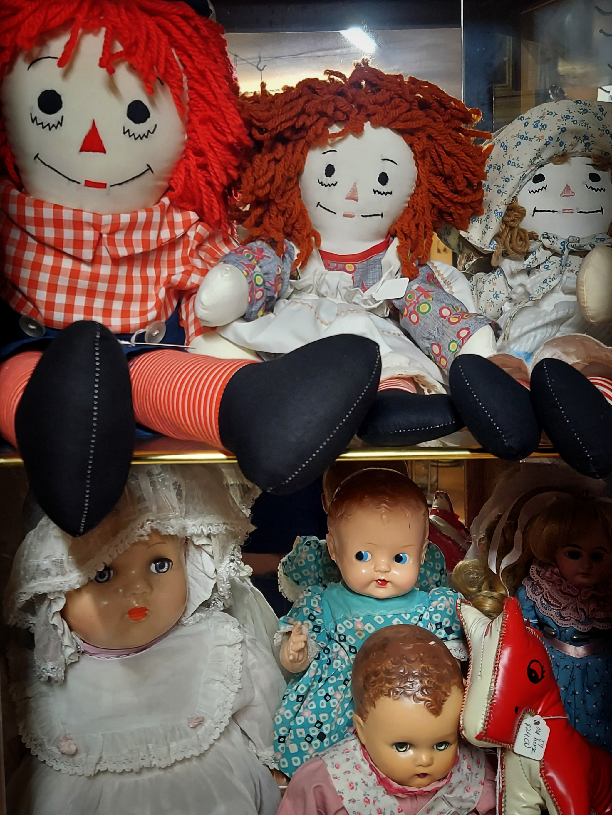 Several antique and vintage dolls, including Raggedy Anns and Andys.