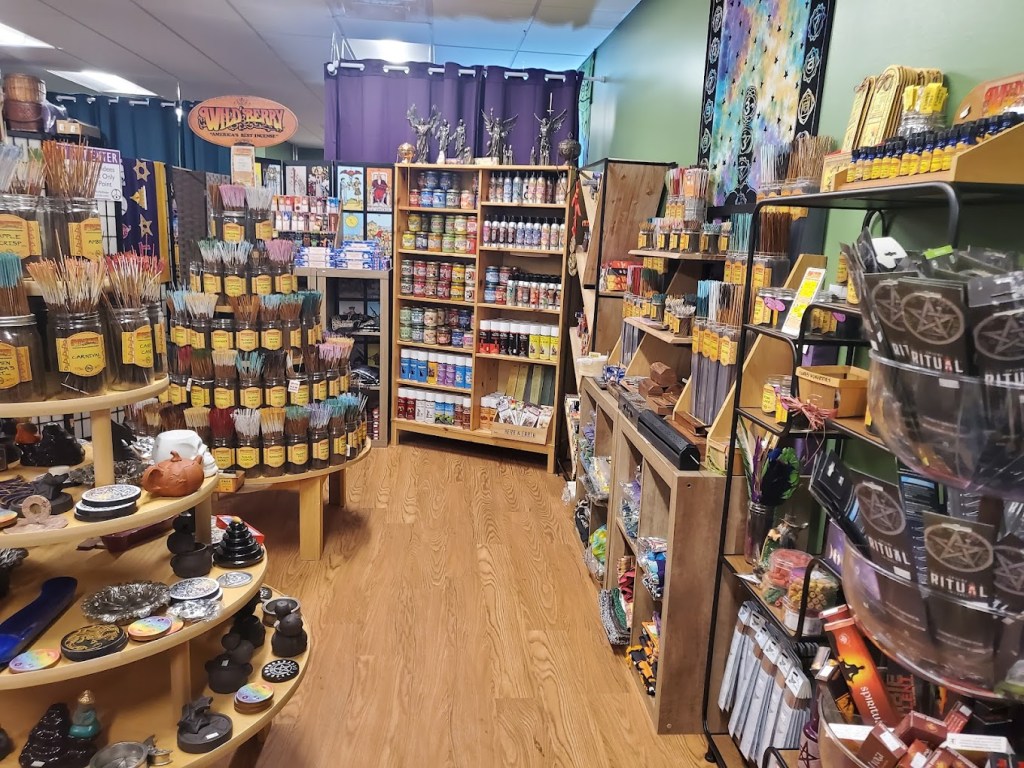 A photo of store displays, showing incense, statues, sprays, and candles. 