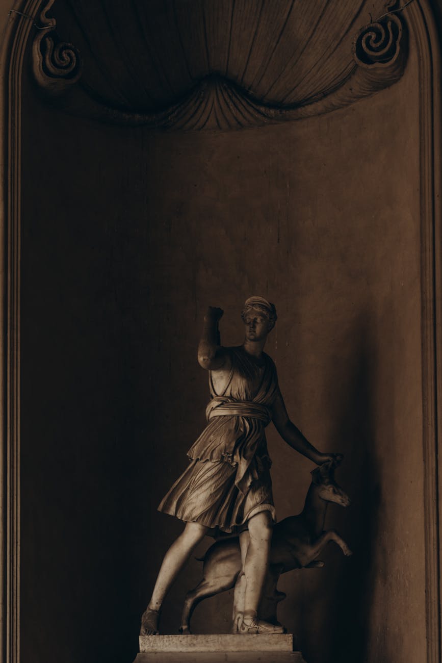 An old statue depicting Artemis alongside a stag.